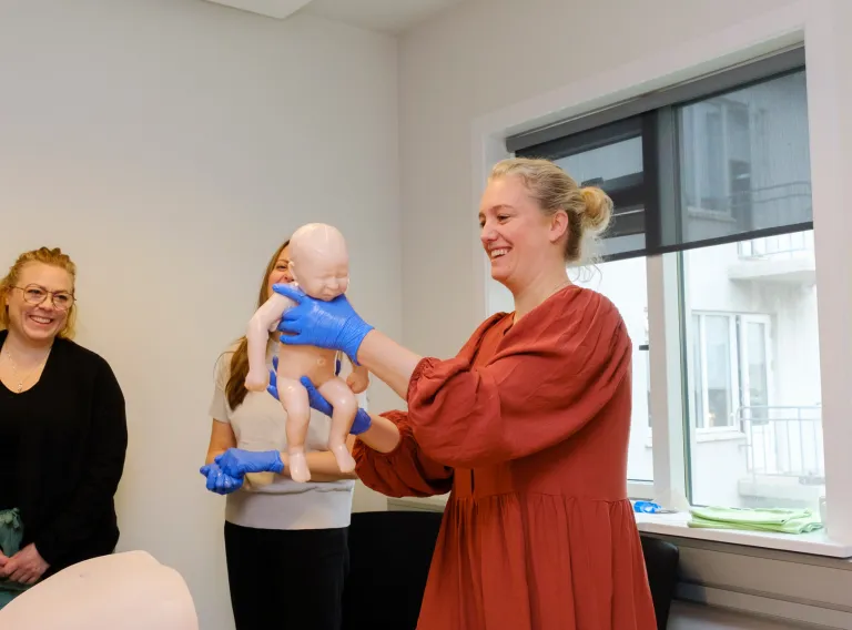 Ljósmóðurfræðinemi æfir sig að halda á barni eftir að hafa tekið á móti því