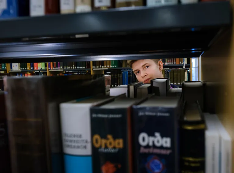 Nemandi og bækur á bókasafni